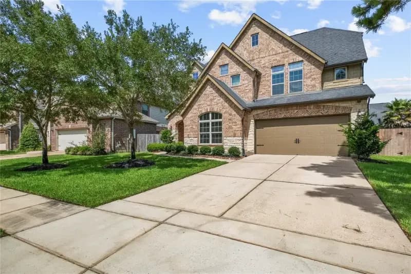 Front exterior of a two story brick home in Eagle Springs, Humble, Texas