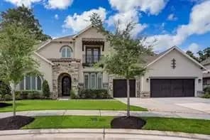 Front exterior of a French style home in Royal Brook at Kingwood, Texas