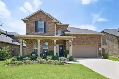 Front exterior of a two story brick home in Spring, Montgomery County, Texas